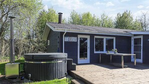 A small building with a hot tub, a deck, and a table with chairs. - 6 Person Holiday Home in Hals (Hals)