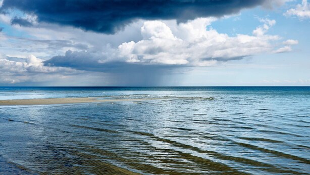 A beach with clear water, a sandy shore, and a cloudy sky. - 6 Person Holiday Home in Hals (Hals)