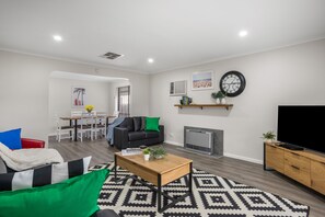 A modern living room with a sofa, coffee table, and a fireplace. - Banksia Rosebud  Pet Friendly (Rosebud)