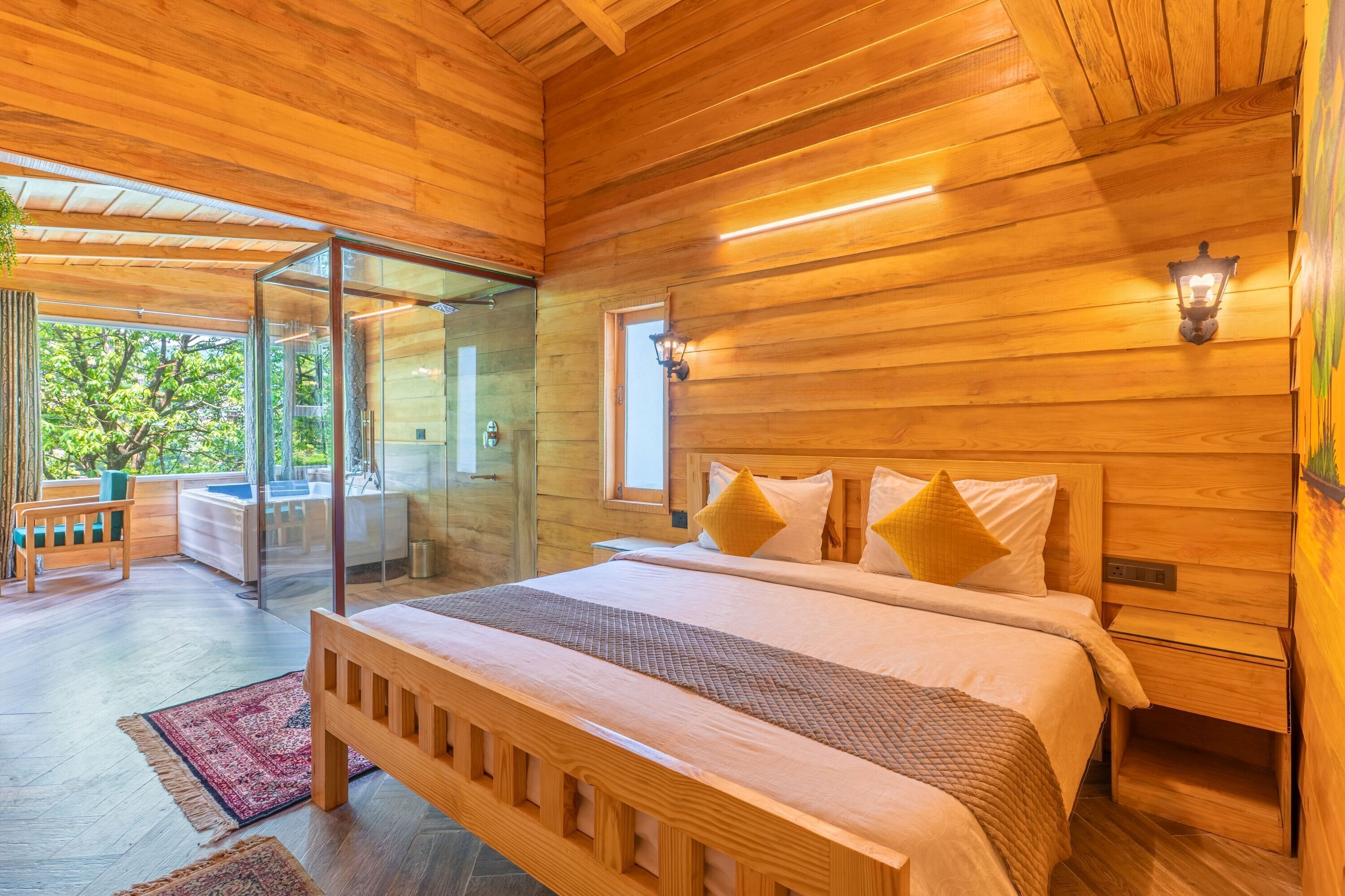 A wooden-paneled bedroom with a large bed, bedside tables, and a glass door leading to an outdoor area.