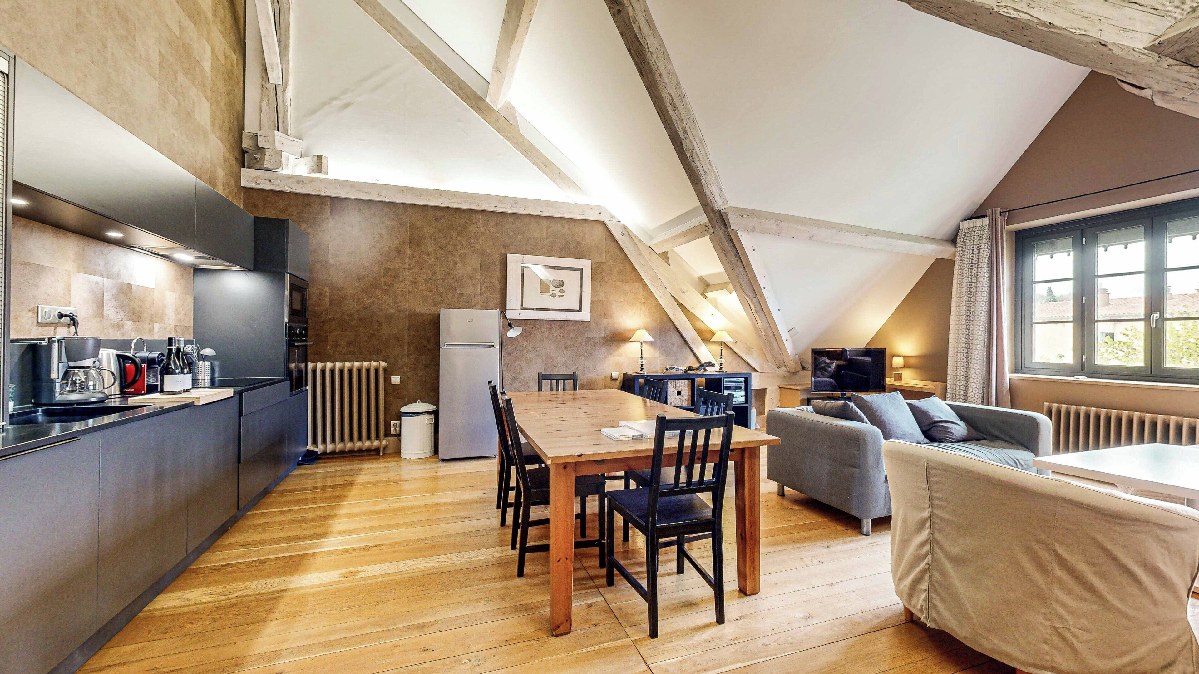 A modern loft with a kitchen, dining area, and living space.
