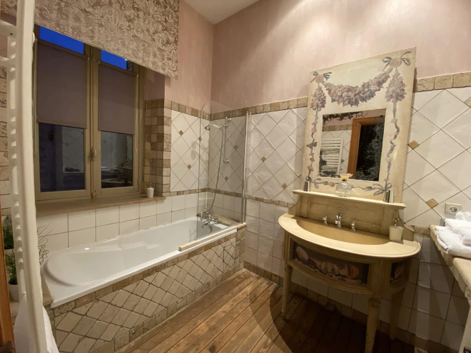 A bathroom with a bathtub, a shower, a sink, and a mirror.
