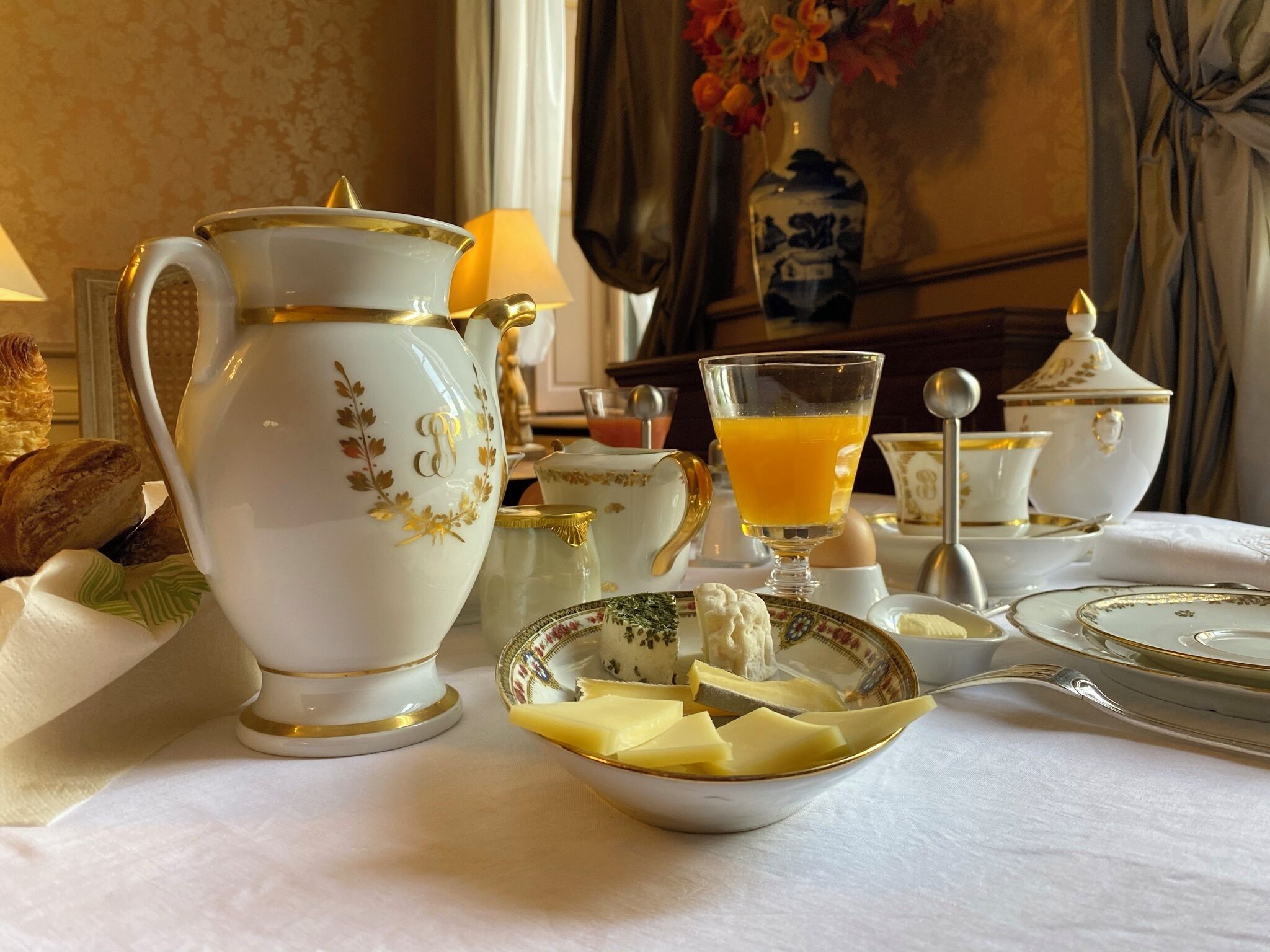 Une table mise pour le petit-déjeuner, avec une carafe, une théière et des tasses.