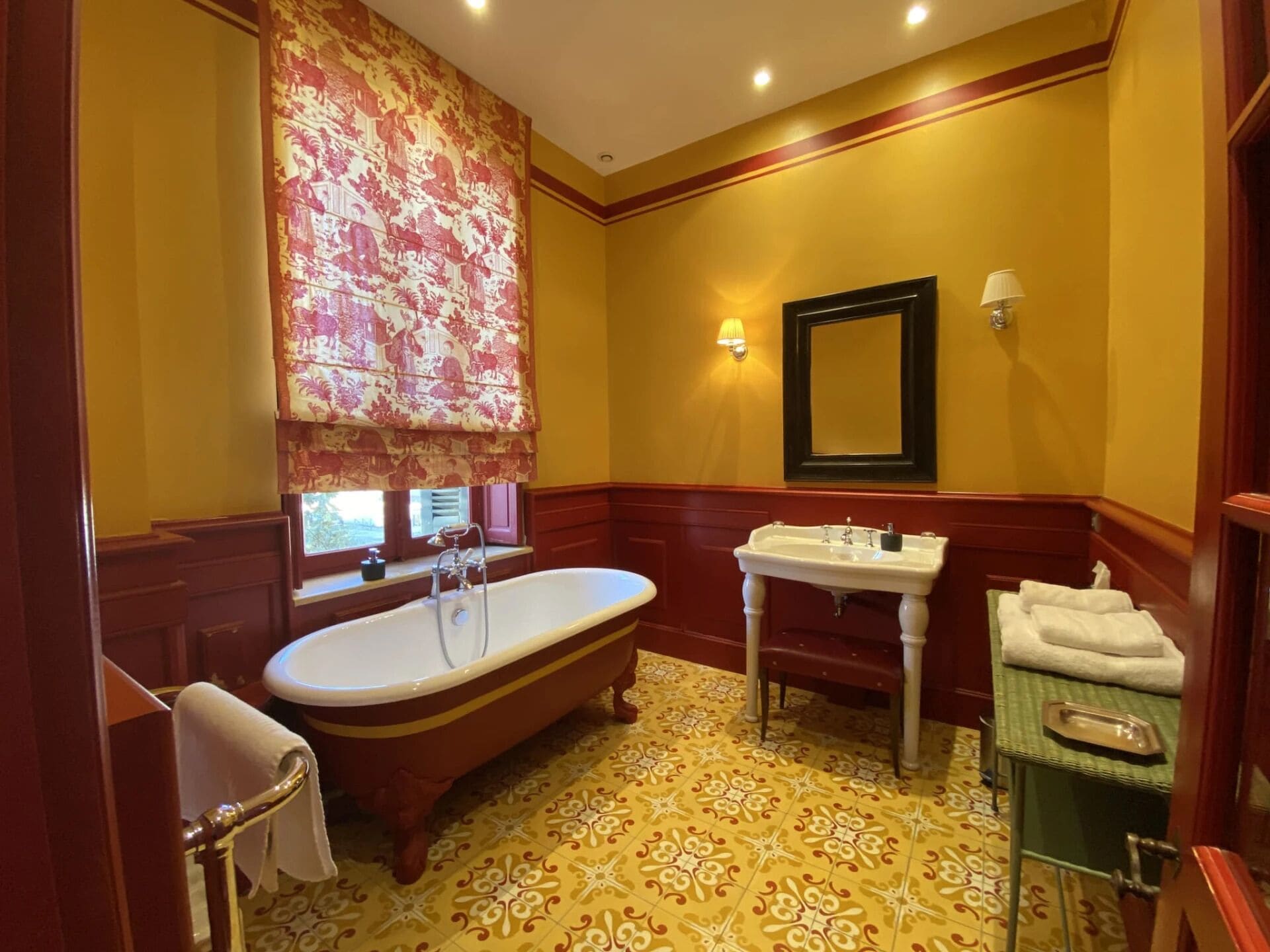 A bathroom with a freestanding bathtub, a vanity with a sink, and a mirror.