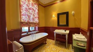 A bathroom with a freestanding bathtub, a vanity with a sink, and a mirror.
