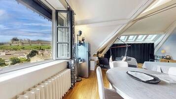 Een balkon met uitzicht op een historisch kasteel, een moderne keuken en een gezellige zithoek.
