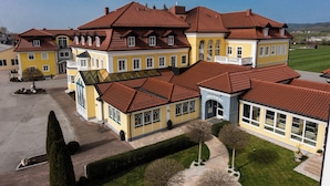 A large, multi-story building with a red-tiled roof, multiple windows, and a well-maintained lawn. - Hotel Jägerwirt (Lengau)
