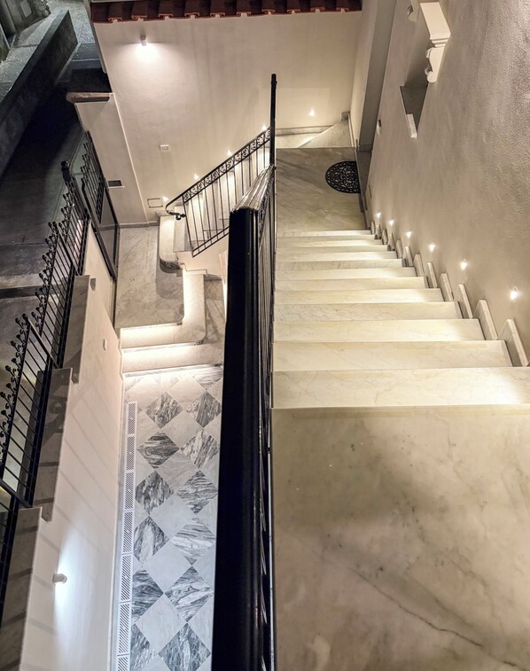 A staircase with a handrail and a patterned floor.