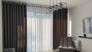 Un saló modern amb un sofà gris, una taula de centre rodona i un butac armchair gris.