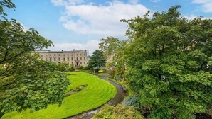 A well-maintained lawn with a curved pathway leading to a building with multiple windows.