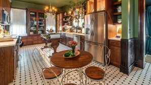 Une cuisine équipée d’une table à manger, de chaises, d’un réfrigérateur et d’un lustre.
