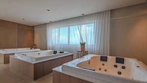 A modern spa room with three hot tubs and a wooden floor. - Comfortable Studio with Ocean View in Armação (Salvador)