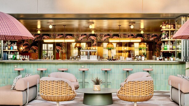 A bar area with wicker chairs, a round table, and a tiled floor. - Charleston Loft | Exclusive Party-Friendly Rental (Charleston)