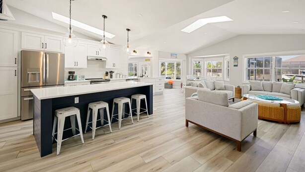 A spacious kitchen with a central island, bar stools, and modern appliances. - Dockside Dreams - Summer Pool and Canal Retreat! (Palm Coast)