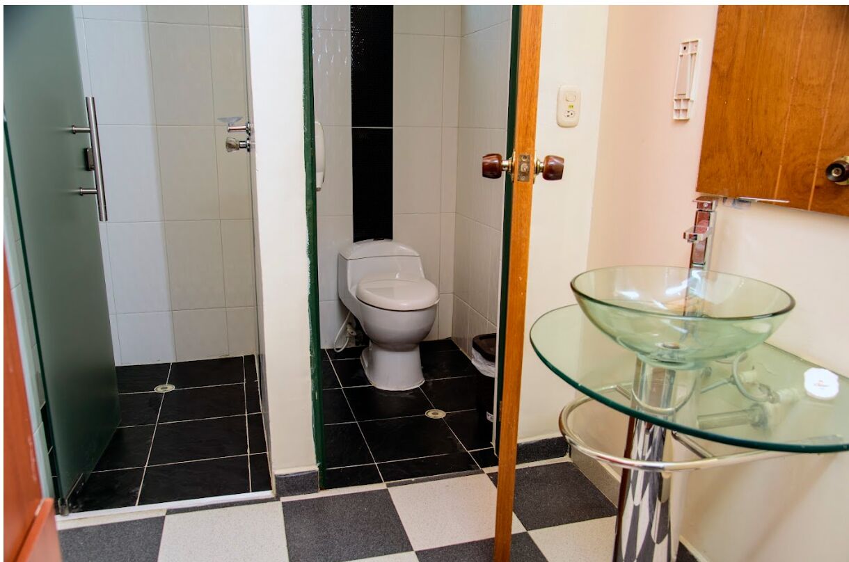 Un bagno con lavabo in vetro, un water e una zona doccia.