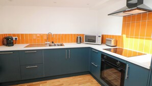 A modern kitchen with a skylight, a microwave, a toaster, and a dishwasher. - Yew Tree Cottage (Matlock)