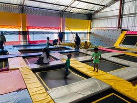 Un área de trampolines en el interior, con múltiples trampolines y superficies acolchadas.