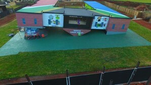 Ein Mehrzweckgebäude mit Sportplatz, überdachtem Bereich und Kinderspielplatz.