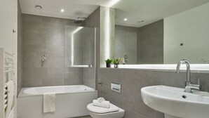 Un baño moderno con bañera, inodoro y lavabo.
