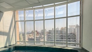 Une piscine sur le toit offrant une vue sur la ville, de grandes fenêtres et un design moderne.