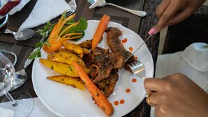 A plate with roasted meat, carrots, and potatoes, accompanied by a fork. - LOISOI RESORT (Thungari)