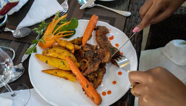 A plate with roasted meat, carrots, and potatoes, accompanied by a fork. - LOISOI RESORT (Thungari)
