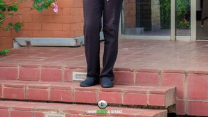 A person standing on a brick staircase outside a building with a glass door and a brick wall. - LOISOI RESORT (Thungari)