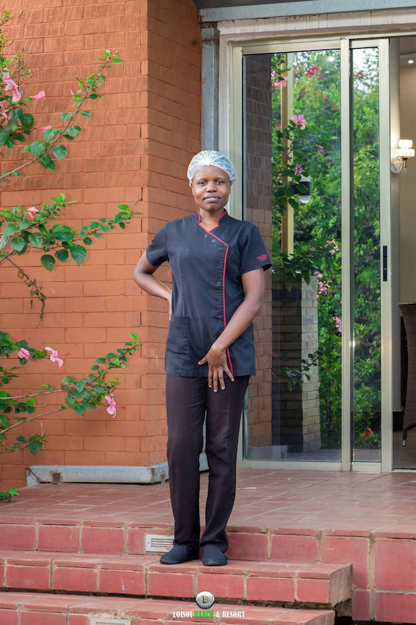 A person standing on a brick staircase outside a building with a glass door and a brick wall.