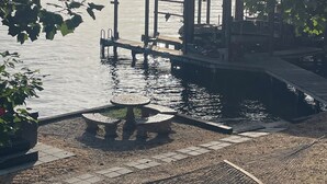 Un belvédère au bord du lac, avec une table et des chaises, un hamac et une jetée qui s’avance dans l’eau.