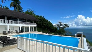 A swimming pool with a white fence, a gym, and a view of the sea. - APARTAMENTO VISTA MARE 9-202 (Samana)