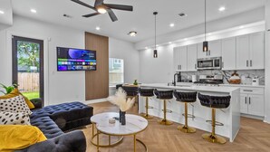 A modern kitchen with white cabinets, a built-in microwave, and a coffee bar. - Luxury 4BR Escape 10mins to NRG stadium, Dwtn HTX, MedCtr, and the Zoo! (Houston)