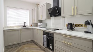 Una cucina moderna con mobili grigi, un forno a microonde nero, un tostapane e una lavastoviglie.