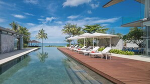 A modern resort with a pool, sun loungers, and a view of the ocean. - Luxe Vacay Beachfront Sava Villa 5 | Villa Malee Sai | Chef & Staff | LTH-16 (Takua Thung)