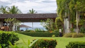 A well-maintained garden with a gazebo, a view of the sea, and a person walking. - Luxe Vacay Beachfront Sava Villa 5 | Villa Malee Sai | Chef & Staff | LTH-16 (Takua Thung)