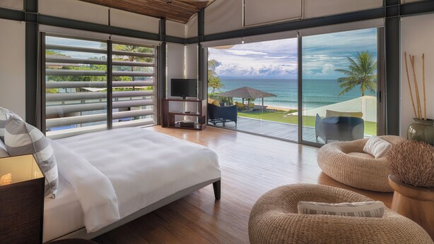 A spacious bedroom with a large bed, a TV, and a view of the ocean. - Luxe Vacay Beachfront Sava Villa 5 | Villa Malee Sai | Chef & Staff | LTH-16 (Takua Thung)