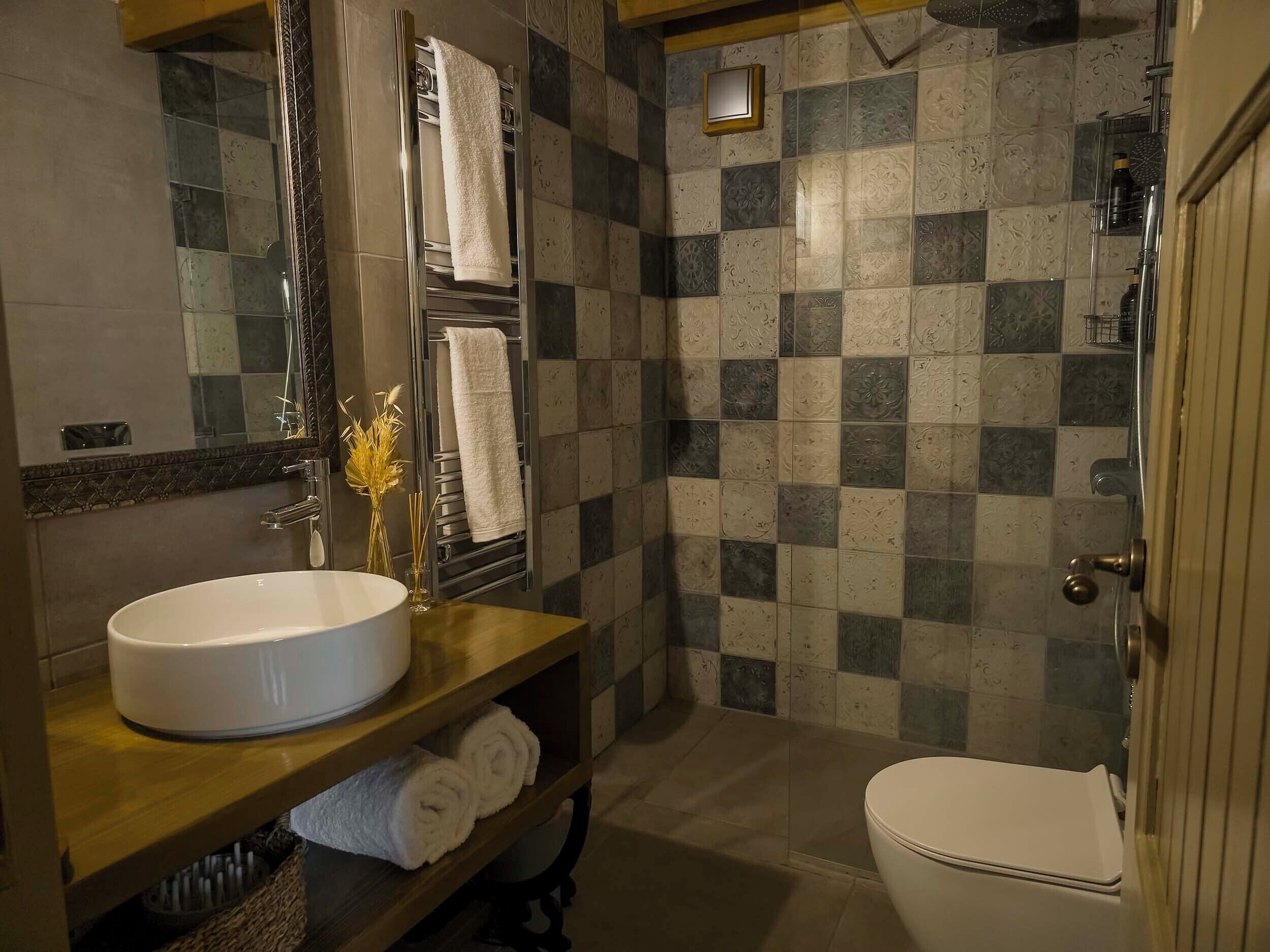 A bathroom with a white sink, a mirror, a towel rack, and a shower area.