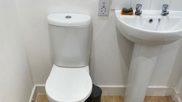 Ein Badezimmer mit Toilette, Waschbecken und Mülleimer.
