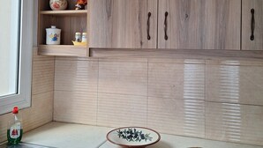 Une cuisine avec des meubles de rangement en bois, un plan de travail et une fenêtre.