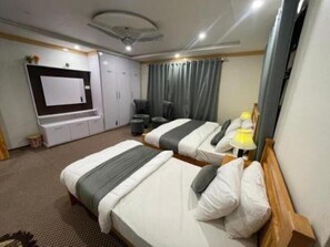 Two single beds, a seating area, and a flat-screen TV make this room a comfortable retreat.