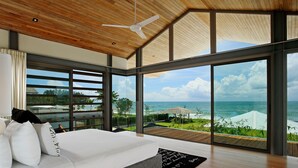 A modern bedroom with a large bed, wooden ceiling, and a view of the ocean. - Luxe Vacay Beachfront Sava Villa 4 | Villa Essenza | Chef & Staff | LTH-15 (Takua Thung)