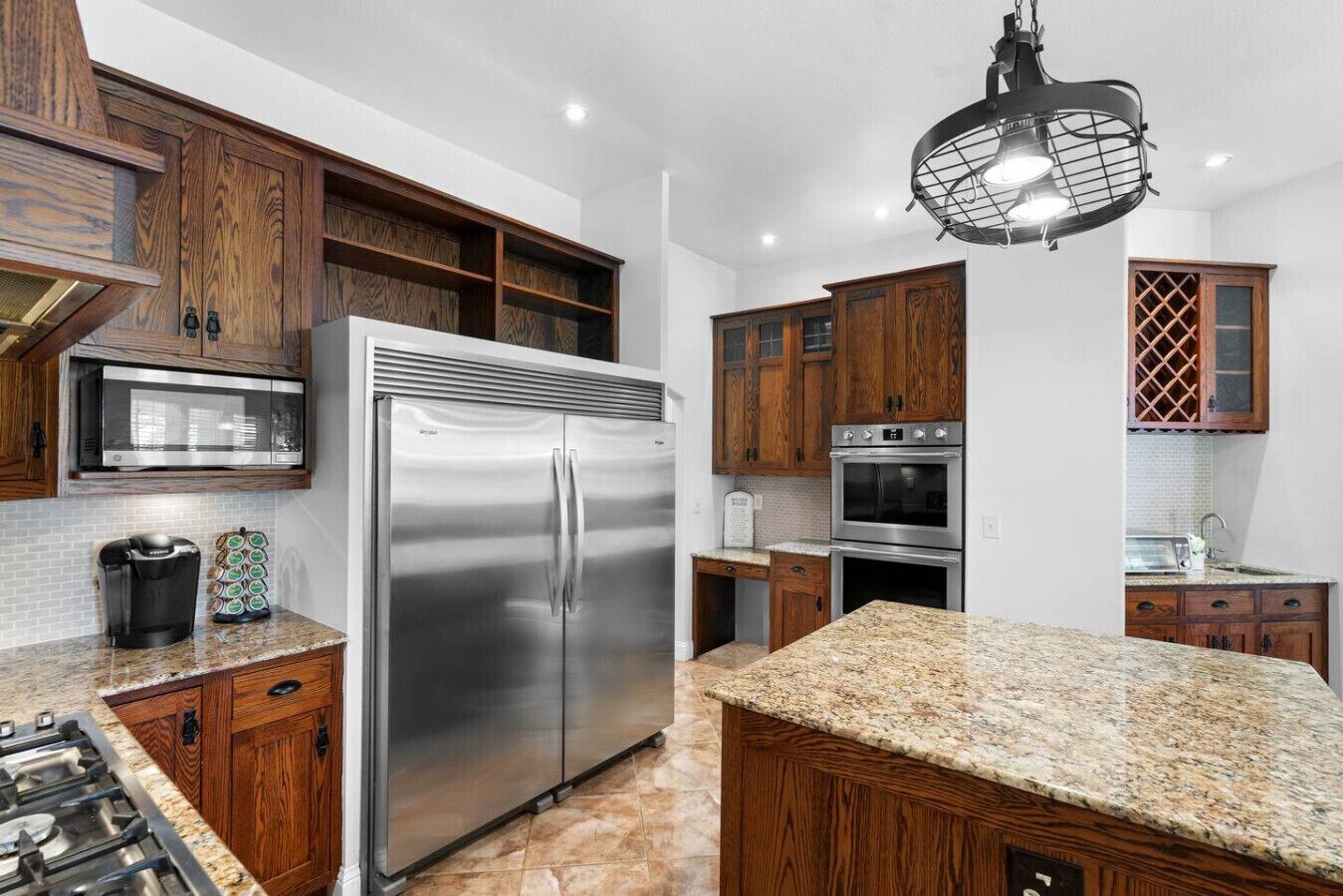 A modern kitchen with wooden cabinets, stainless steel appliances, and a granite countertop.