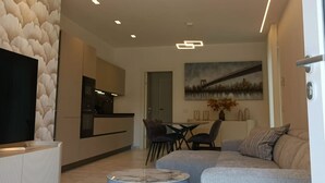 A modern living room with a sofa, a coffee table, and a flat-screen TV.