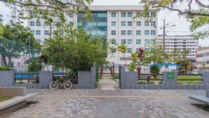 A paved walkway leading to a building with a modern design, surrounded by greenery and a bicycle parked by the entrance. - Apto Confort vel Tima Localiza o e pet Friendly (Teresópolis)