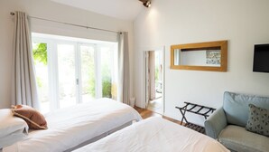 Una habitación de hotel con dos camas, un sofá, una mesa de madera y un espejo en la pared.