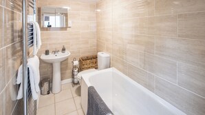 Un baño moderno con bañera, lavabo e inodoro.