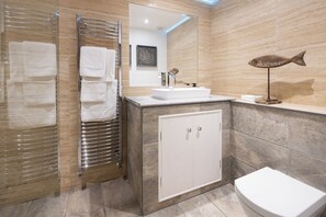 A modern bathroom with a glass shower enclosure, a white sink, and a toilet. - The Dovecote 3-bed Cottage, Rowden Manor (Chippenham)
