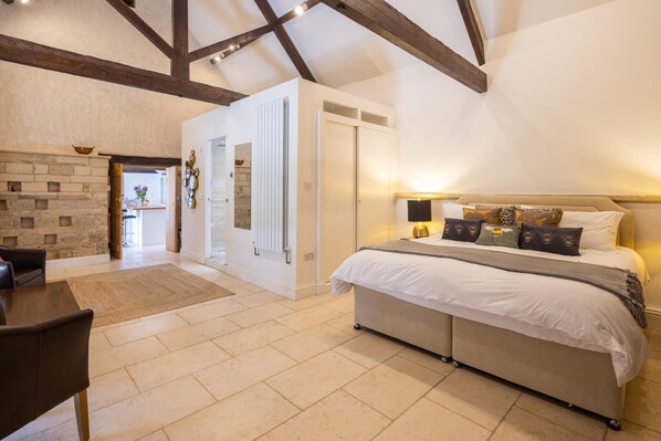 A bedroom with a bed, bedside table, lamp, and decorative pillows. - The Dovecote 3-bed Cottage, Rowden Manor (Chippenham)