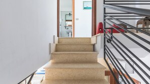 A staircase with beige steps leading to a landing. - Appartamento Terrazza by BarbarHouse (Porto Cesareo)