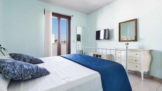 A bedroom with a bed, a dresser, a TV, and a mirror. - Appartamento Terrazza by BarbarHouse (Porto Cesareo)