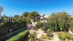 A residential area with a pathway, greenery, and a building in the background. - I Sognatori - Bilo Plus by BarbarHouse (Torre Squillace)
